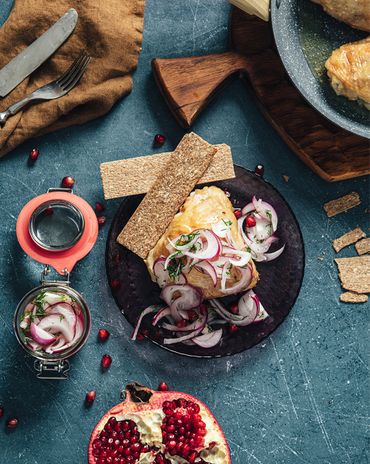 Запеченные куриные бедрышки с маринованным красным луком, зернами граната и цельнозерновыми хлебцами фото к рецепту